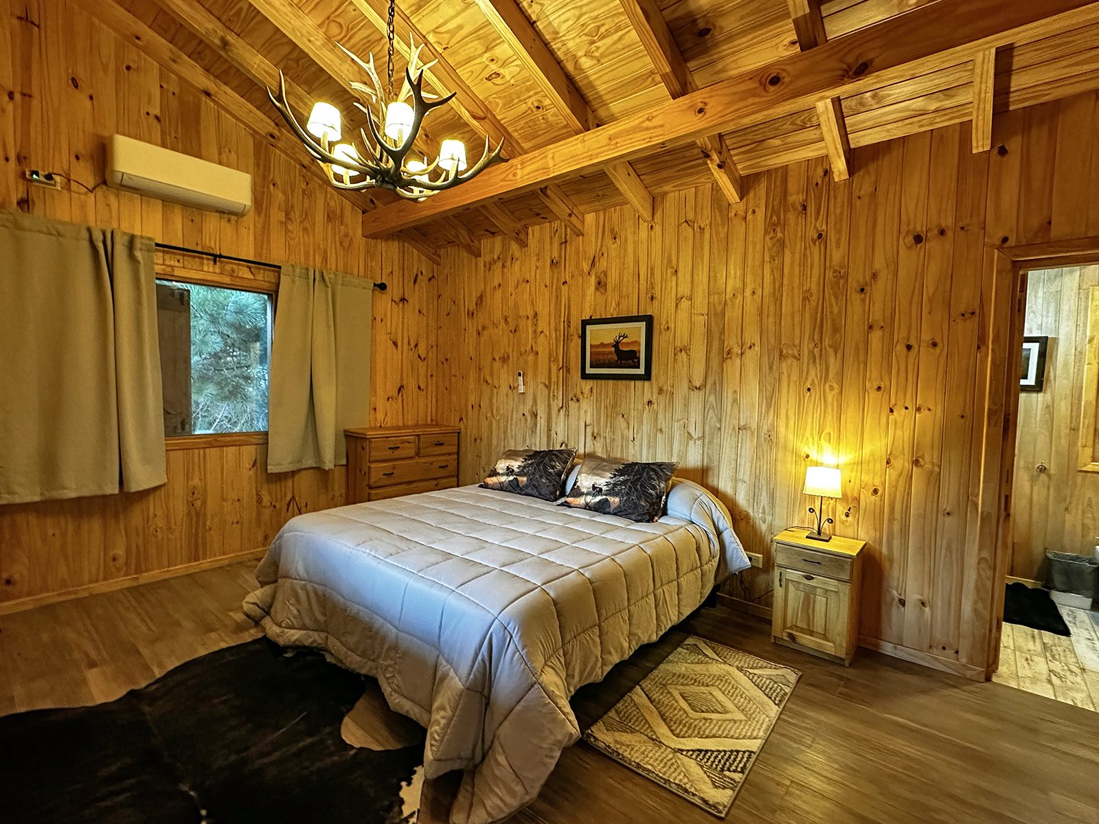 Cozy lodge bedroom with antler chandelier