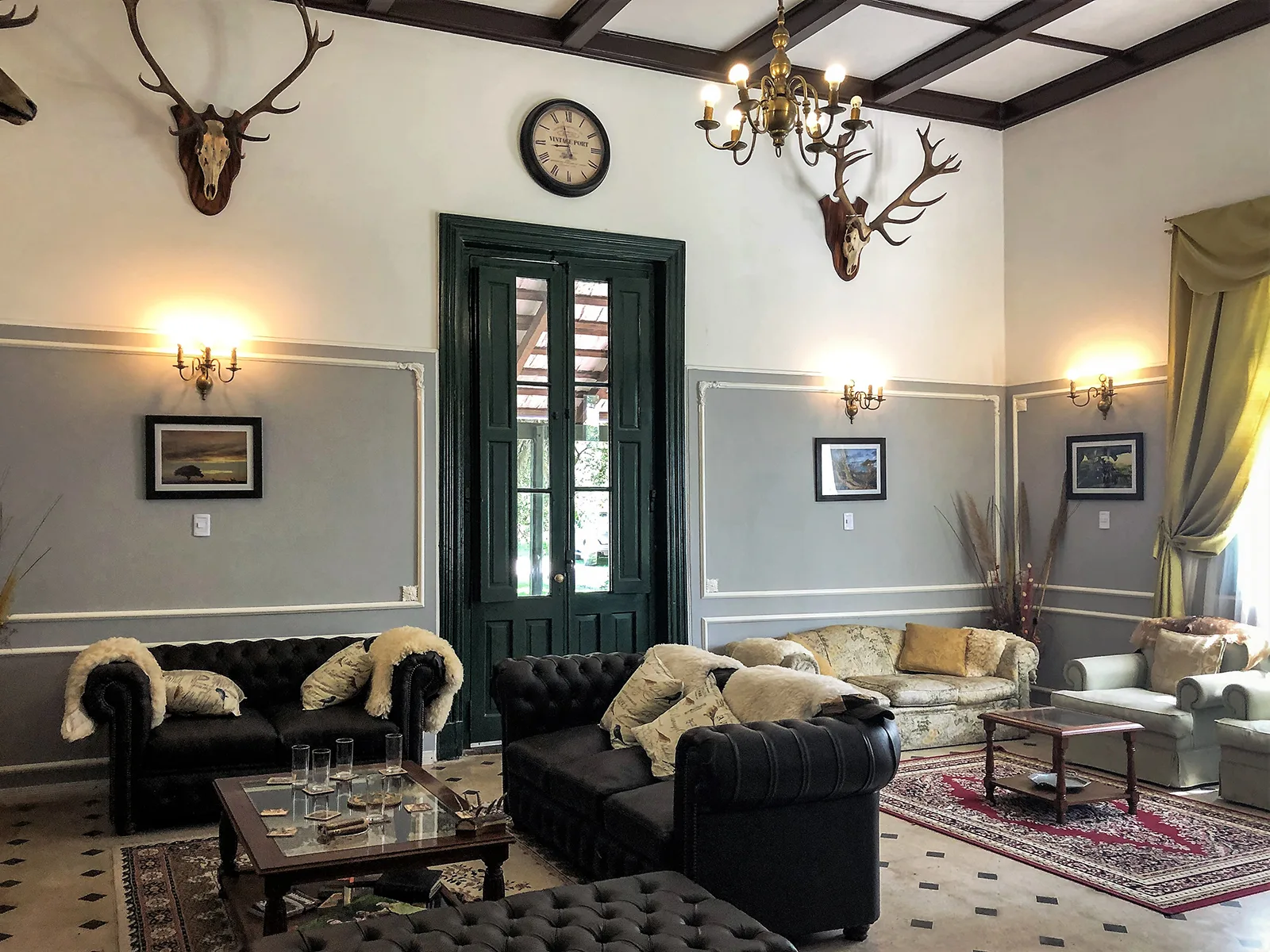 Elegant estancia living room with Chesterfield sofas and deer mounts