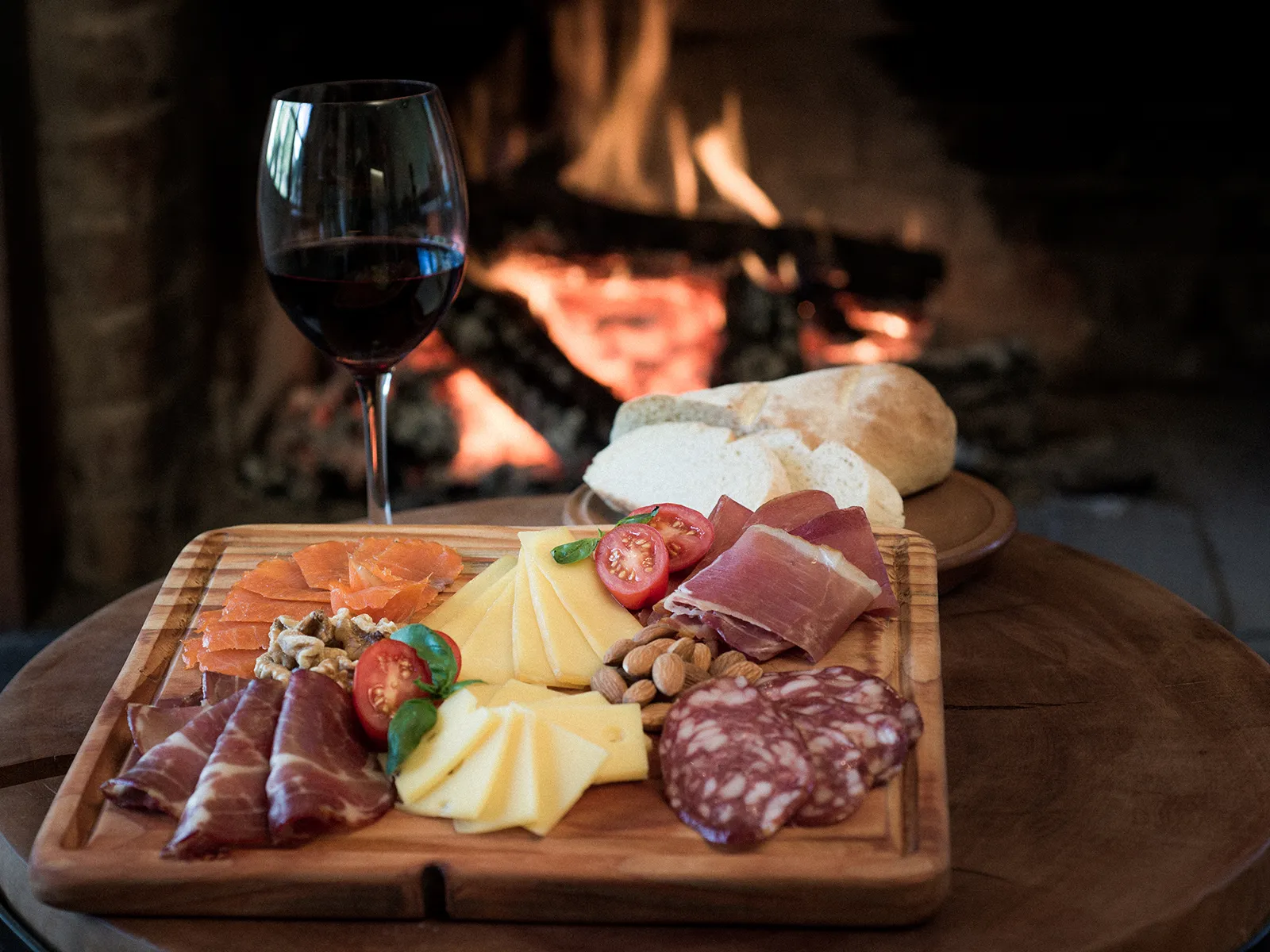 Charcuterie board with wine by the fireplace